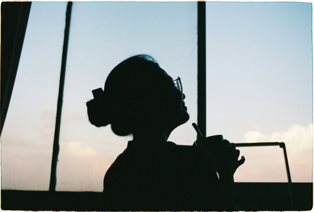 夜に考え事をして眠れないイメージの女性のシルエット